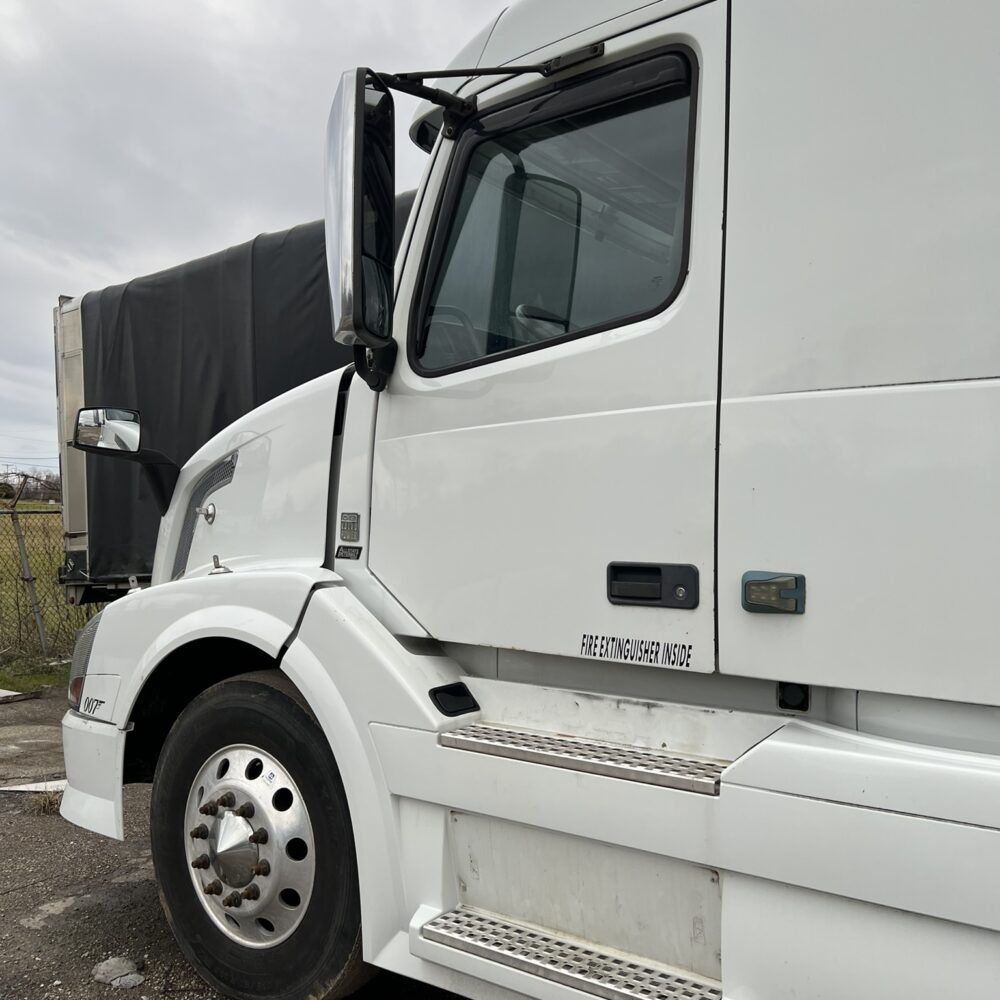 Driver side profile of white Volvo semi truck with clean exterior.