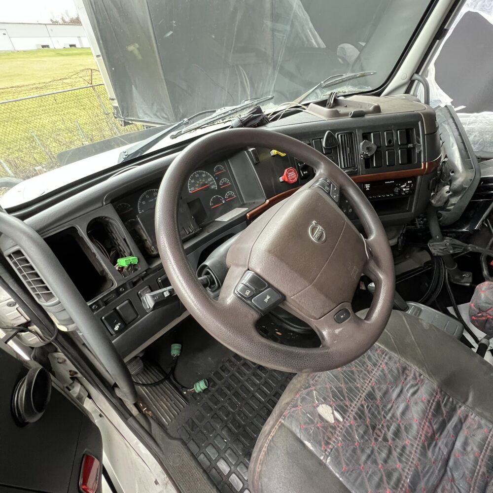 Interior of Volvo semi truck showing steering wheel and dashboard.